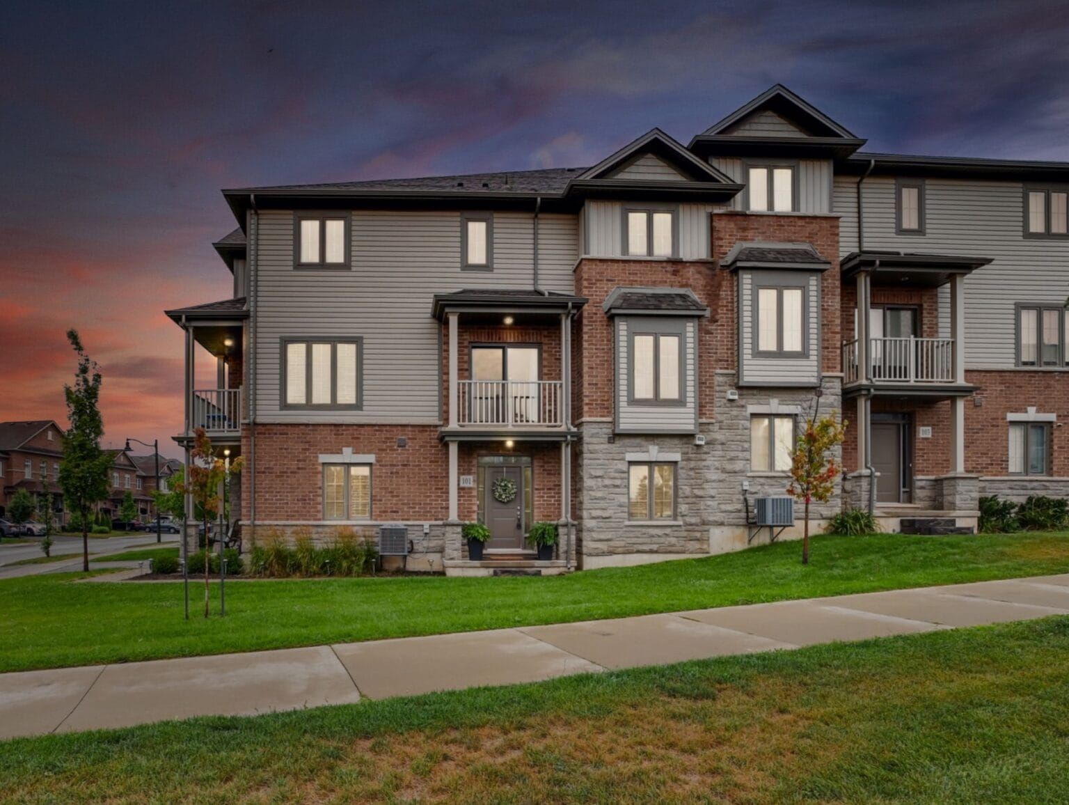 Brick and siding townhome at dusk, Mallard Trail, Waterdown
