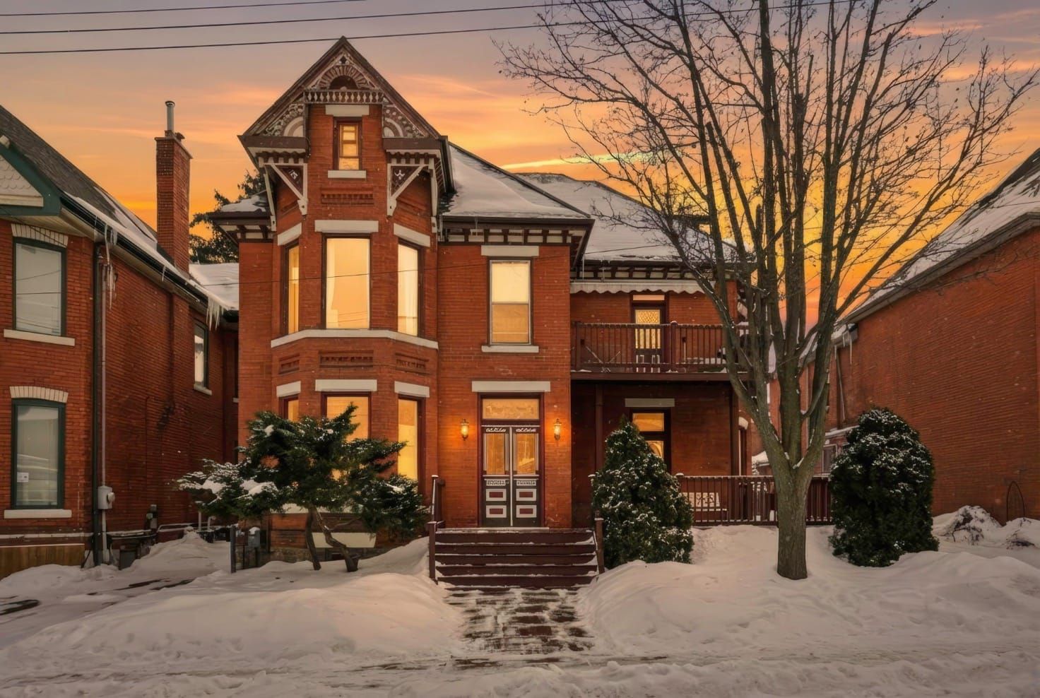 Victorian red-brick home with bay window at sunset, Ontario Avenue, Hamilton