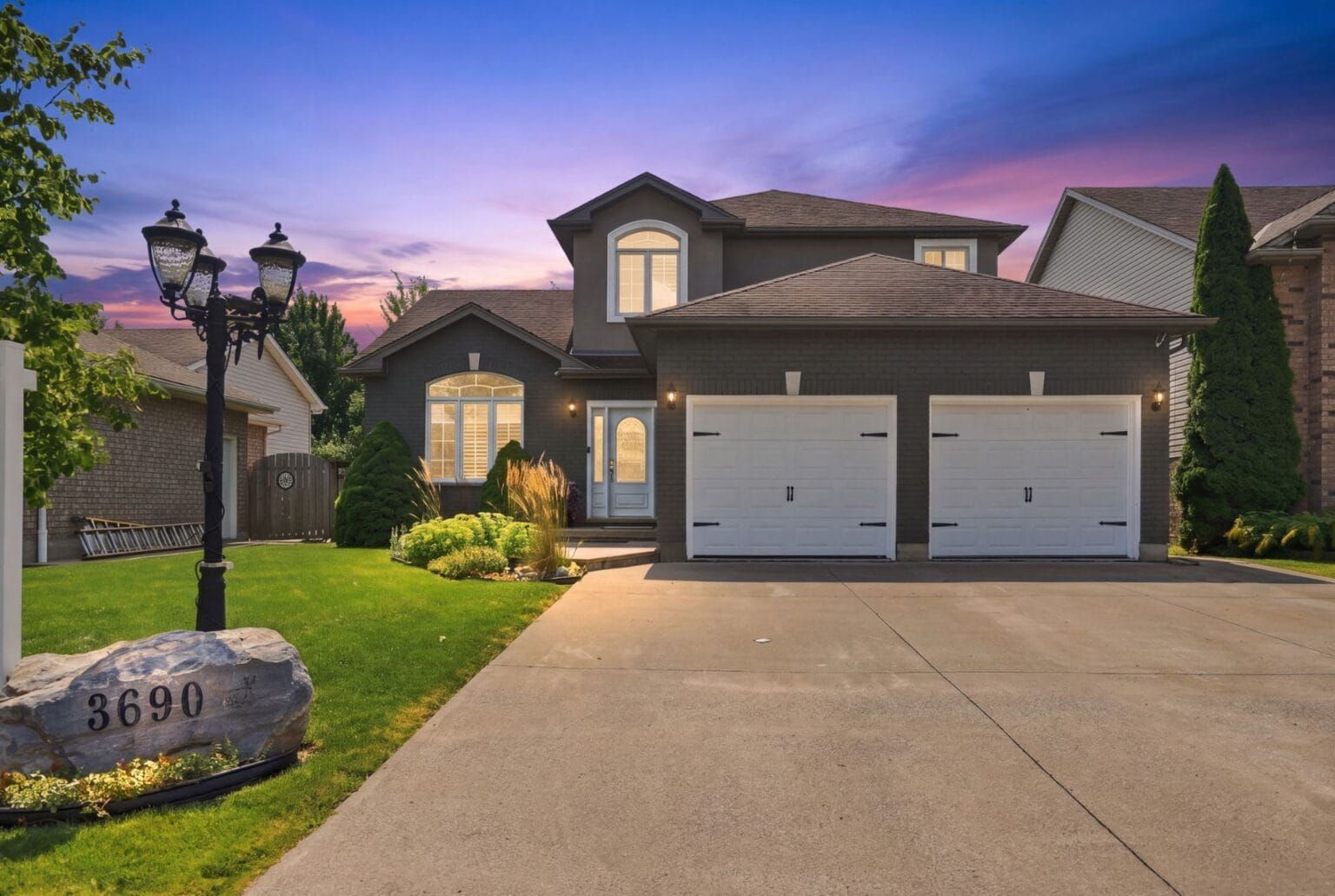 Two-storey home with double garage at dusk, Weinbrenner Road, Niagara Falls