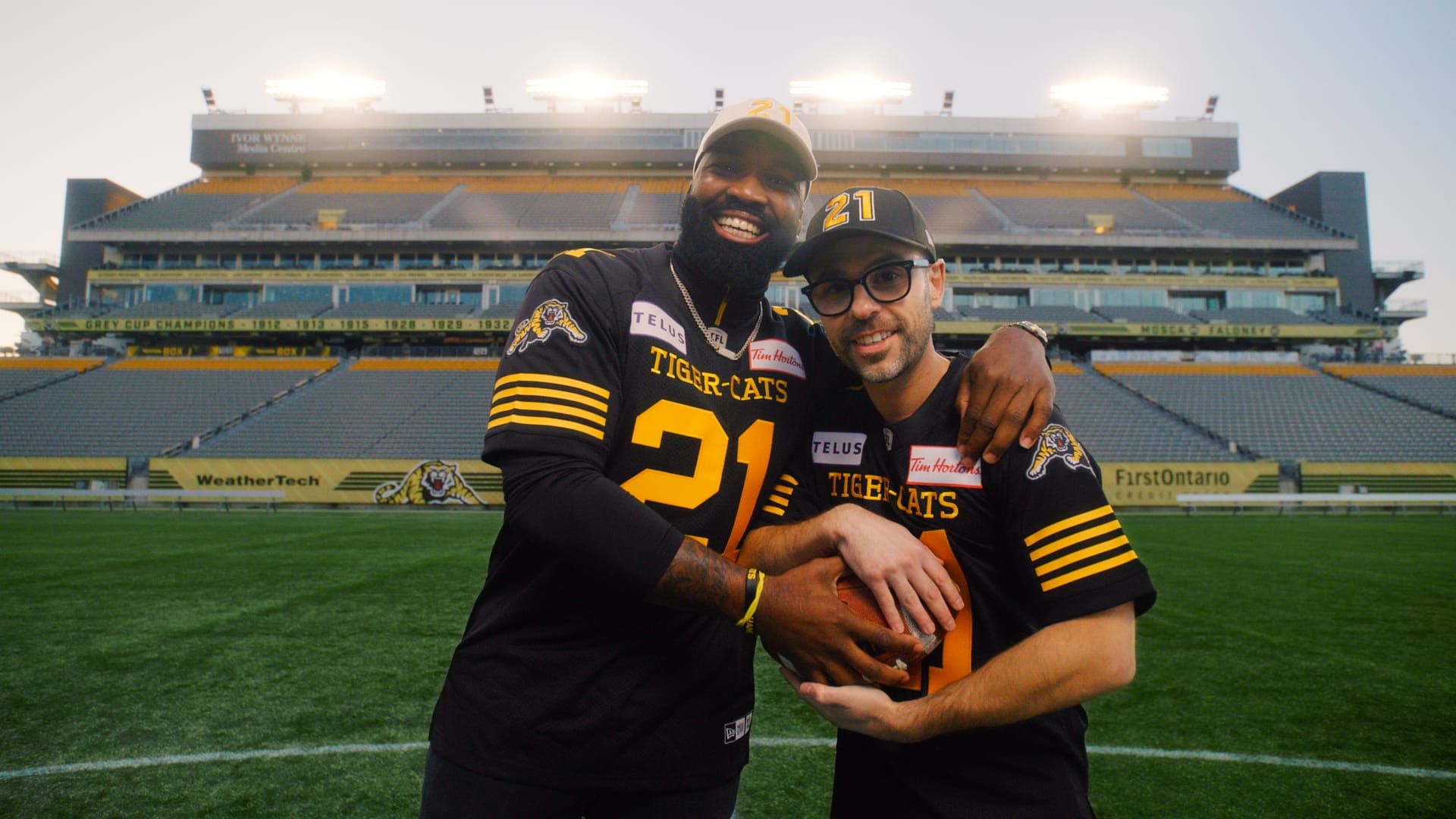 Michael St. Jean with a Hamilton Tiger-Cats player on the field at Hamilton Stadium